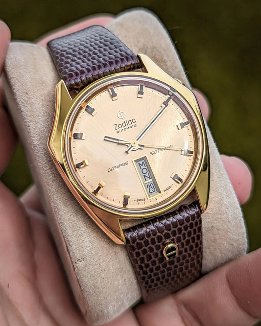 Vintage Zodiac SST 36000 automatic gold wristwatch with day date display and brown textured leather strap